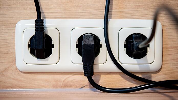 Die Netzstecker mehrerer Küchengeräte stecken in einer Steckdose an einer Küchenzeile. (Symbolbild)
