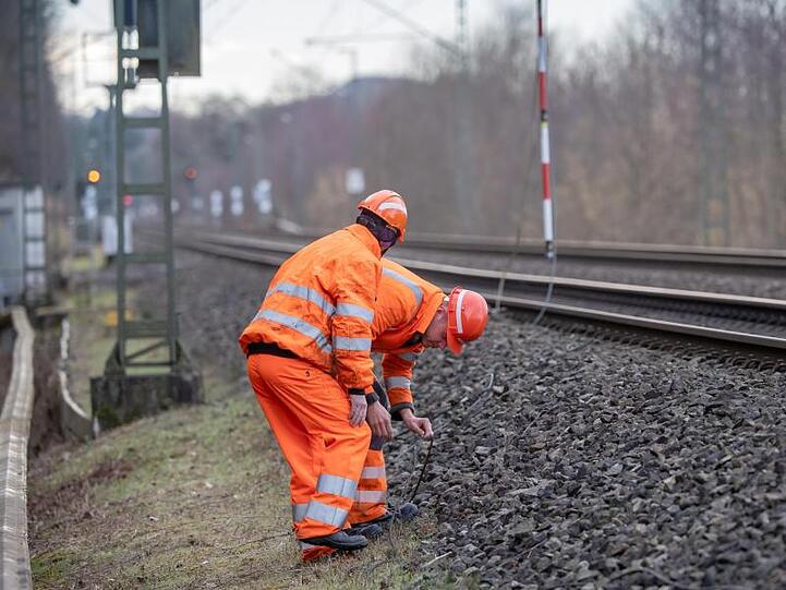 Zwei Bahnarbeiter untersuchen auf der Bahnstrecke zwischen Fürstenfeldbruck-Eichenau und München eine gerissene Leitung, die anschließend repariert wird.