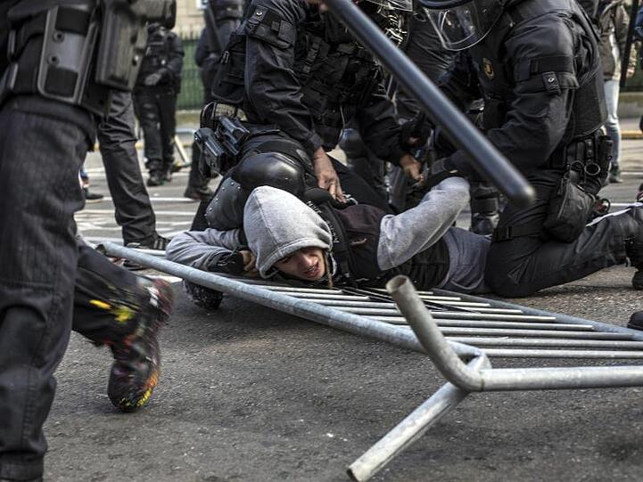 Die Polizei nimmt einen jungen Demonstranten fest.