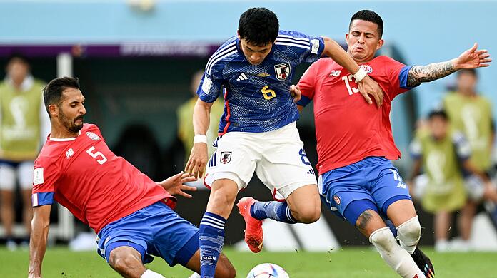 Der Japaner Wataru Endo (M) wird von Costa Ricas Celso Borges (l) und Gerson Torres (r) in die Zange genommen.