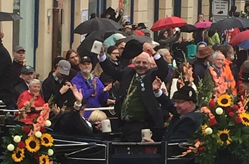 Wiesn-Stadtrat Otto Seidl winkt während des Trachtenumzugs von seiner Kutsche.