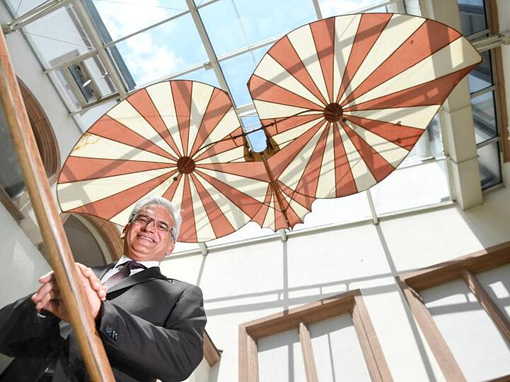 Gunter Czisch steht unter dem Nachbau des Fluggeräts, das Albrecht Ludwig Berblinger. Foto: Felix Kästle/dpa/Archivbild