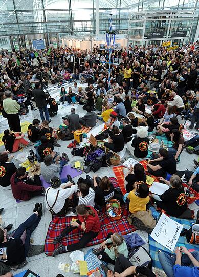 Gegen Fluglärm demonstrierende Demonstranten picknicken am Samstag (24.03.12) am Flughafen Franz-Josef-Strauss in einem Teil der Abflughalle des Terminal 2.