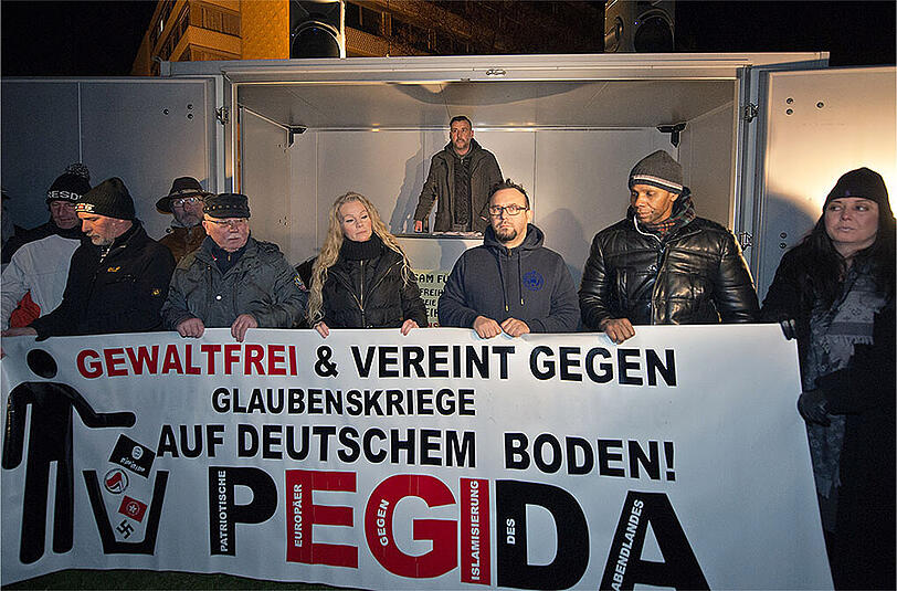 Pegida-Chef Lutz Bachmann (Mitte hinten) spricht am 08.12.2014 in Dresden auf der Pegida Kundgebung. Heute ist eine weitere Demo in Dresden geplant.