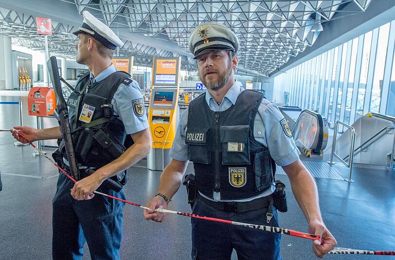 Polizisten sperren den Abflugbereich des Frankfurter Flughafens ab. In anderen Bereichen des Flughafens lief der Betrieb normal weiter. Foto: Boris Roessler/dpa