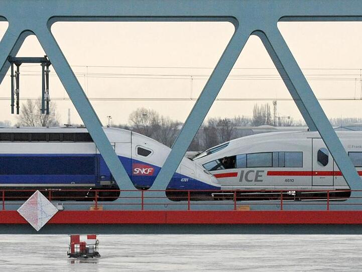 Ein TGV und ein ICE (r) stehen auf einer Rheinbrücke. Foto: Marijan Murat/Archiv