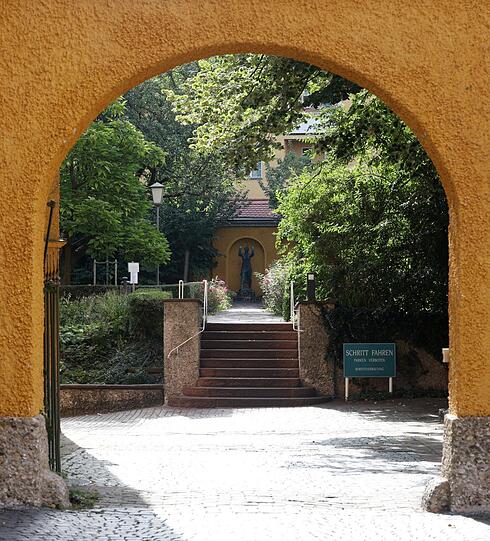 Durchblick durch einen Bogen in einen weiteren Garten.