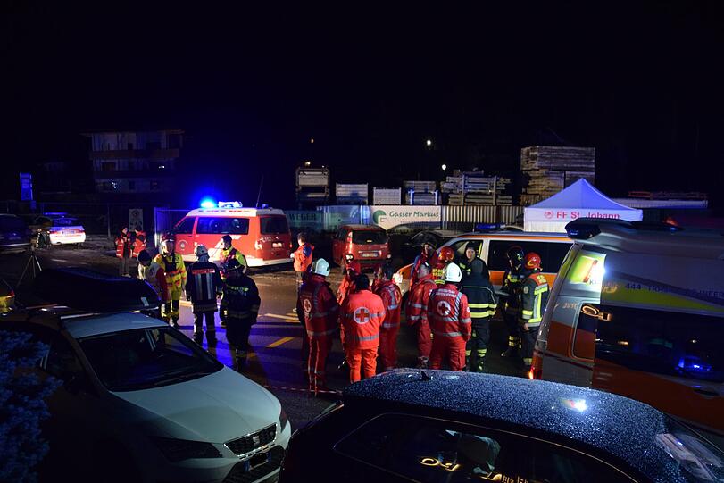 Einsatzkräfte der Freiwilligen Feuerwehr Luttach und des italienischen Roten Kreuzes sind an einer Unfallstelle in der Nähe von Bruneck in der Gemeinde Ahrntal in Südtirol zu sehen. Hier ist in der Nacht zum Sonntag ein Auto in eine Reisegruppe gefahren und hat sechs Menschen tödlich verletzt.