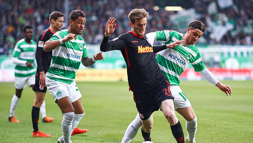 Die Fürther Lukas Petkov (r) und Armindo Sieb (l) kämpfen mit dem Regensburger Scott Kennedy um den Ball.