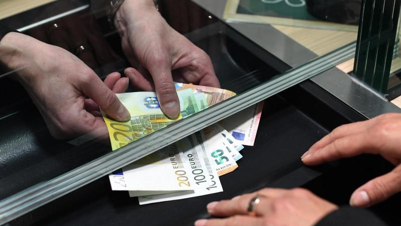 Eine Frau lässt sich in einer Bankfiliale am Schalter Bargeld auszahlen. Eine Frau lässt sich in einer Bankfiliale am Schalter Bargeld auszahlen.