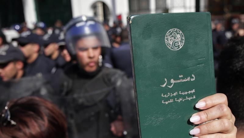 Eine Demonstrantin hält eine Kopie der algerischen Verfassung hoch während eines Protestmarsches gegen die Entscheidung des algerischen Präsidenten Bouteflika, trotz angeschlagener Gesundheit für eine fünfte Amtszeit zu kandidieren. Eine Demonstrantin hält eine Kopie der algerischen Verfassung hoch während eines Protestmarsches gegen die Entscheidung des algerischen Präsidenten Bouteflika, trotz angeschlagener Gesundheit für eine fünfte Amtszeit zu kandidieren.