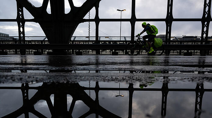 Ein Radfahrer auf der Hackerbrücke: Zum Wochenende hin kündigen sich Schauer und Gewitter an.