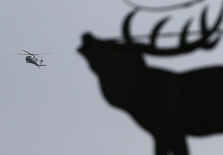 Der letzte Hubschrauber des Konvois von US-Präsident Obama verlässt Garmisch. Der Hirsch auf einem Wirtshausschild schaut zu.