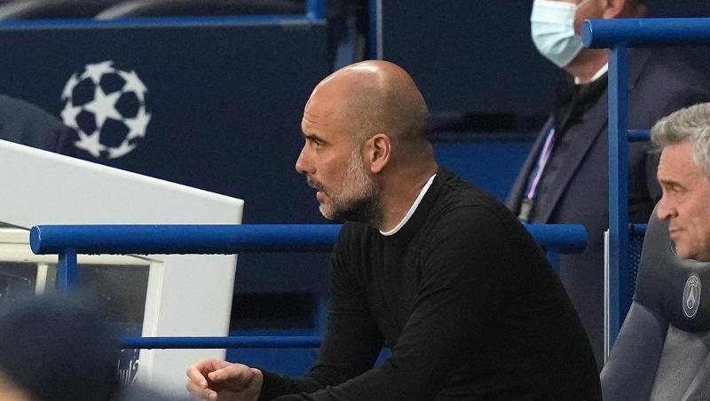 Pep Guardiola, Trainer von Manchester City, sitzt auf der Bank und beobachtet das Spiel.