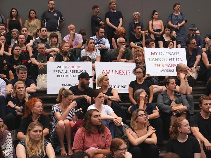 Menschen sitzen auf den Stufen des australischen Parlaments, um an der Mahnwache für die 21-jährige Israelin teilzunehmen.