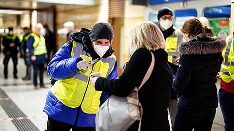 Ein Kontrolleur der MVG überprüft bei einer Schwerpunktaktion am U-Bahnhof Stachus den Impfnachweis einer Frau.