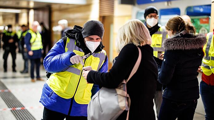 Ein Kontrolleur der MVG überprüft bei einer Schwerpunktaktion am U-Bahnhof Stachus den Impfnachweis einer Frau.