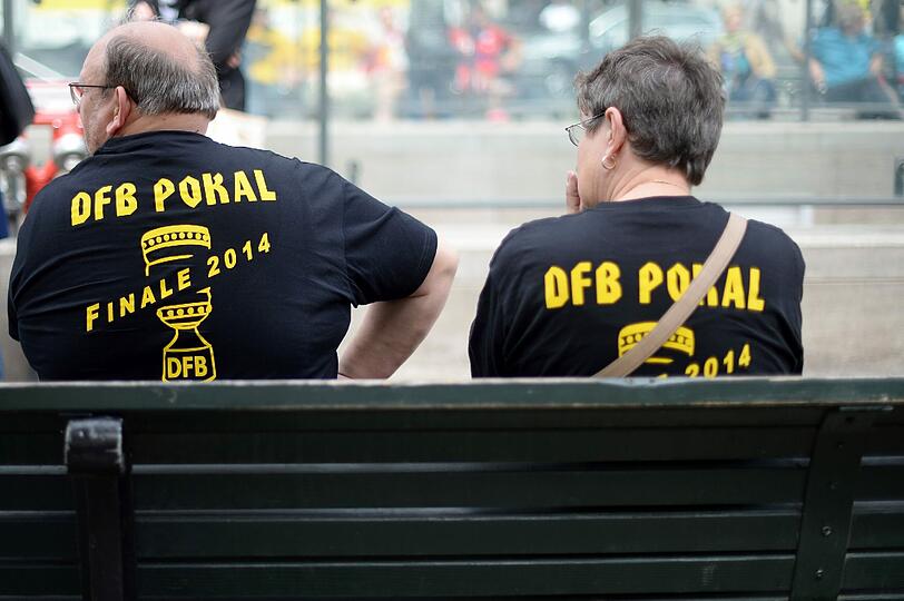 Wer viel feiert, muss sich auch ausruhen. Diese beiden BVB-Fans sitzen auf einer Bank vor dem Brandenburger Tor.