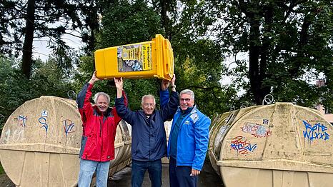 Von links.: Andreas Ellmaier, Ulrich Grasberger und Walter Worbs vom Verein Müllwende feiern die Gelbe Tonne als Teilerfolg. Doch sie finden das Müllsystem Münchens immer noch ineffizient. Über die Gelbe Tonne jubeln sie und haben bereits eine gekauft, zu Foto- und eben Jubelzwecken. Im Bild ist eine 80 Liter große Gelbe Tonne. Laut Grasberger kostet sie 49 Euro.