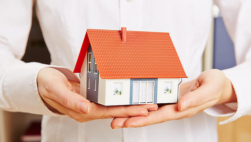 Hände halten Haus als Versicherung Hände halten Haus als Versicherung