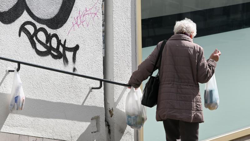 Die Pandemie verschärft die soziale Ungleichheit - manch einer ist auf die Hilfe von Fremden angewiesen, wie hier eine Frau an einem Gabengeländer.
