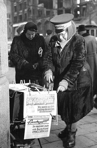 Auf dem Hut der Zeitungsverkäuferin am Hauptbahnhof steht "Abendzeitung".