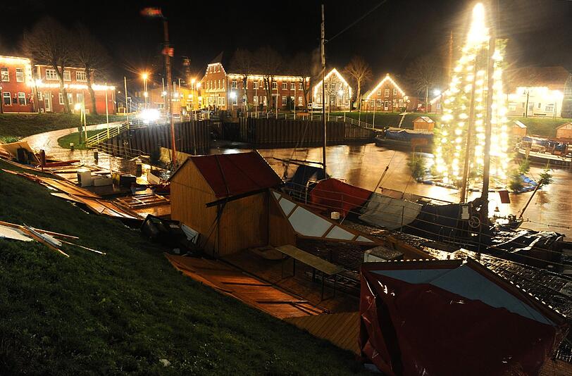 Ein Teil der Buden des Weihnachtsmarktes rund um den Museumshafen in Carolinensiel liegt zerstört auf derr Pier.