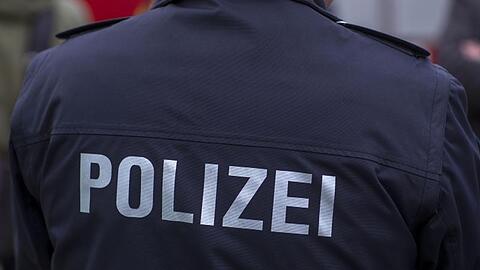 "Polizei" steht auf der Uniform eines Polizisten.