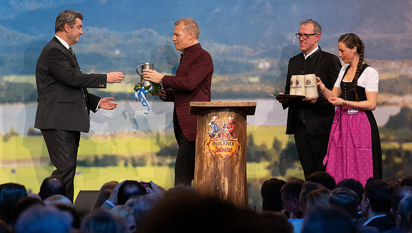 Markus Söder (CSU;l-r,), Ministerpräsident von Bayern, Andreas Steinfatt, Paulaner-Chef, und Christian Dahncke, Paulaner-Braumeister, stehen beim Starkbieranstich auf dem Nockherberg auf der Bühne. Mit dem traditionellen Verspotten, dem «Derblecken» von Politikern am Münchner Nockherberg, wird traditionell die Starkbier-Saison in Bayern eröffnet.