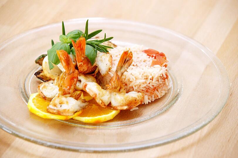Nicht beschränkt auf bayerische Küche: Es gibt auch Fleischgerichte, Pasta, Salate und Kreationen wie hier die Scampi mit Tomatenreis.