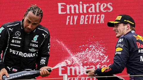 Rivalen Max Verstappen (r) und Lewis Hamilton lassen auf dem Podium den Champagner spritzen.