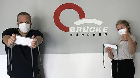 Die Brücke-Mitarbeiter Sophia Edelmann und Michael Steininger präsentieren die Masken.