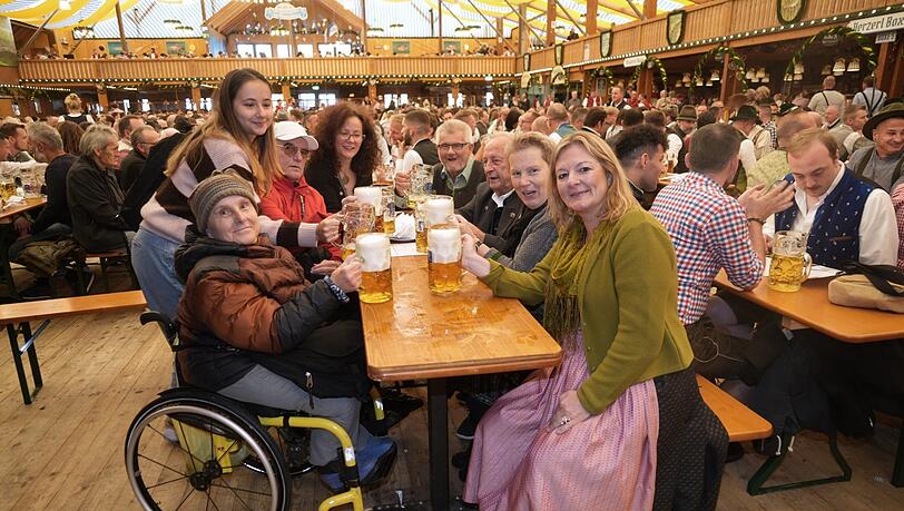 In der Fischer Vroni gibt es einen rollstuhlangepassten Tisch. Wiesn-Stadträtin Anja Berger (vorne rechts) stößt mit an.