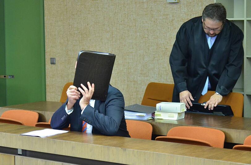 Versicherungsmakler Rainer F. (58) versteckt sich im Münchner Landgericht hinter einer Aktenmappe.