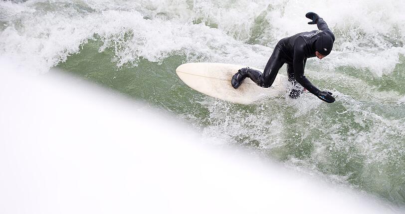 So ein Surfer auf dem Eisbach im Englischen Garten der am Mittwoch seiner Leidenschaft frönte. Wellenreiten bei Minusgraden - trotz Neopren-Fäustlingen wahrlich nichts für Warmduscher!