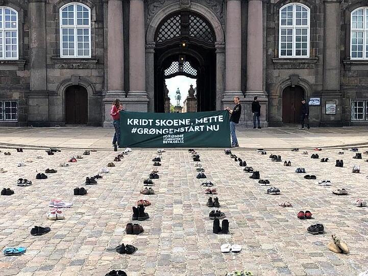 Mit in Reih und Glied aufgestellten Schuhen protestieren dänische Demonstranten vor dem Parlament in Kopenhagen für stärkere Klimaanstrengungen ihrer Regierung.