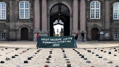 Mit in Reih und Glied aufgestellten Schuhen protestieren dänische Demonstranten vor dem Parlament in Kopenhagen für stärkere Klimaanstrengungen ihrer Regierung.