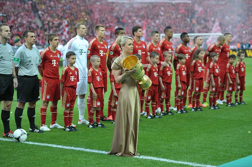 12. Mai 2012. Die zurückgetretene Biathletin Magdalena Neuner trägt den DFB-Pokal zum Finale ins Berliner Olympiastadion. Die zweite Chance auf einen Titel in dieser Saison für den FC  Bayern. Und schon wieder heißt der Gegner Borussia Dortmund.