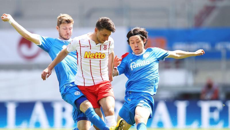 Alexander Mühling (l) und Lee Jae-Sung von Holstein Kiel bedrängen Charalampos Makridis von Regensburg. Foto: Alexander Hassenstein/Getty Images Europe/Pool/dpa Alexander Mühling (l) und Lee Jae-Sung von Holstein Kiel bedrängen Charalampos Makridis von Regensburg. Foto: Alexander Hassenstein/Getty Images Europe/Pool/dpa