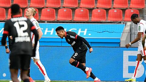Leverkusens Stürmer Leon Bailey (M) juebelt über sein Tor zum 1:0.