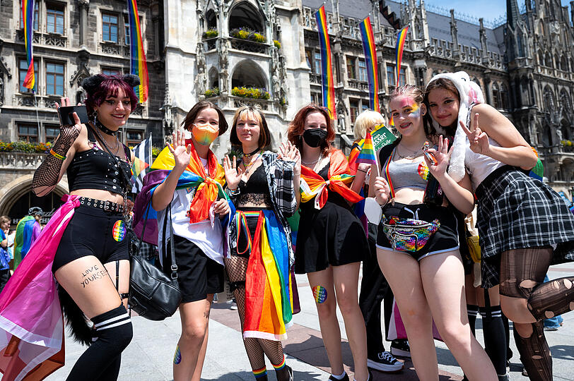 Teilnehmer des Christopher Street Days (CSD) stehen auf dem Marienplatz vor dem Rathaus.