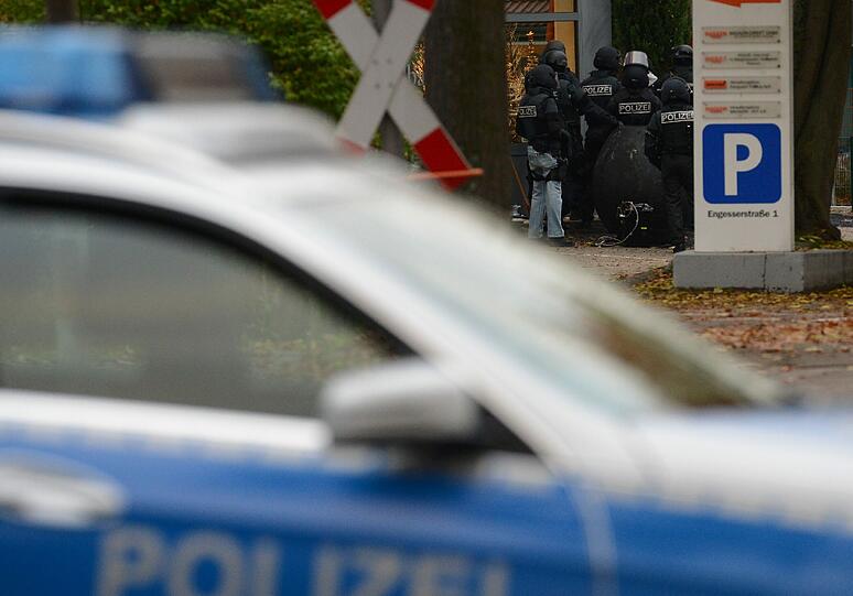 Mit erhobenen Händen kommt ein Mann auf die SEK-Beamten zu, im Hintergrund lauern Heckenschützen der Polizei. Die Beamten nehmen den Mann fest, es ist aber nicht der Täter, der sich in einem Imbiss in Freiburg veschanzt hat.