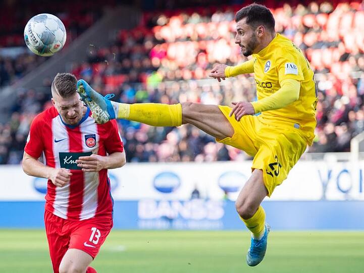Der Bielefelder Jonathan Clauss (r) geht mit hohem Bein in den Zweikampf mit Robert Leipertz vom 1. FC Heidenheim.