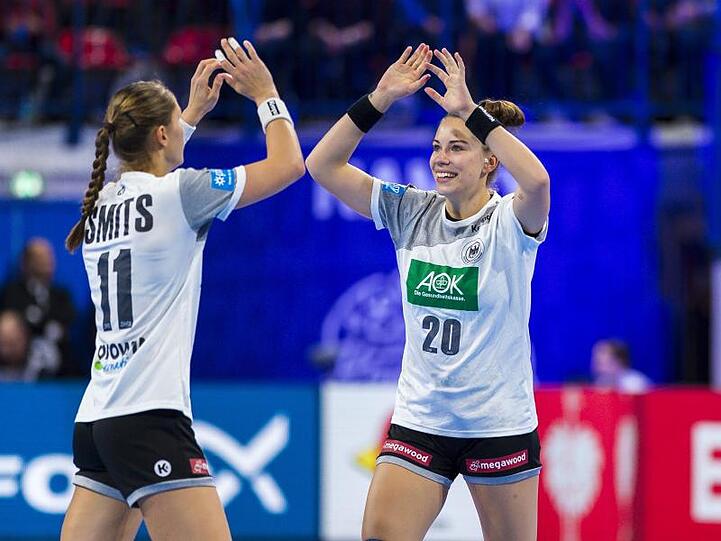 Xenia Smits (l) und Emily Bölk klatschen sich nach einem Torerfolg ab.