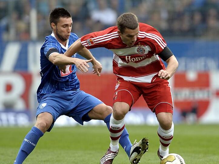 Der Münchner Lukas Podolski (r) und Marc Pfertzel vom VfL Bochum kämpfen um den Ball.