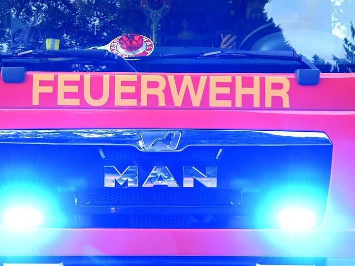 Feuerwehrmänner sitzen in ihrem Fahrzeug. Foto: Carsten Rehder/dpa