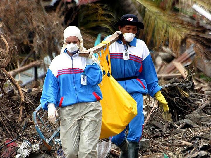 Helfer bergen in Banda Aceh die Leiche eines Tsunami-Opfers.
