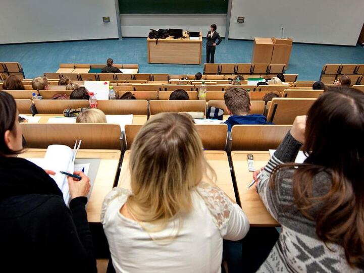 Studenten sitzen in einem Hörsaal und verfolgen eine Vorlesung. Foto: Robert Schlesinger/dpa