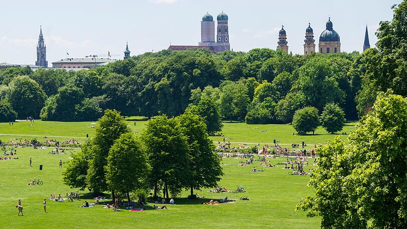 Zahlreiche Personen liegen im Englischen Garten in München.