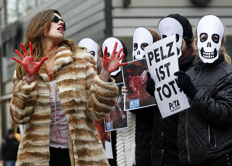 Mit "blutigen" Pelzmänteln protestieren PETA-Aktivistinnen am 23.11.2012 in Düsseldorf gegen das Tragen von Pelzmänteln. Anlass der Aktion auf einer Einkaufsmeile ist der "Fur-Free-Friday" - der Pelzfreie Freitag.